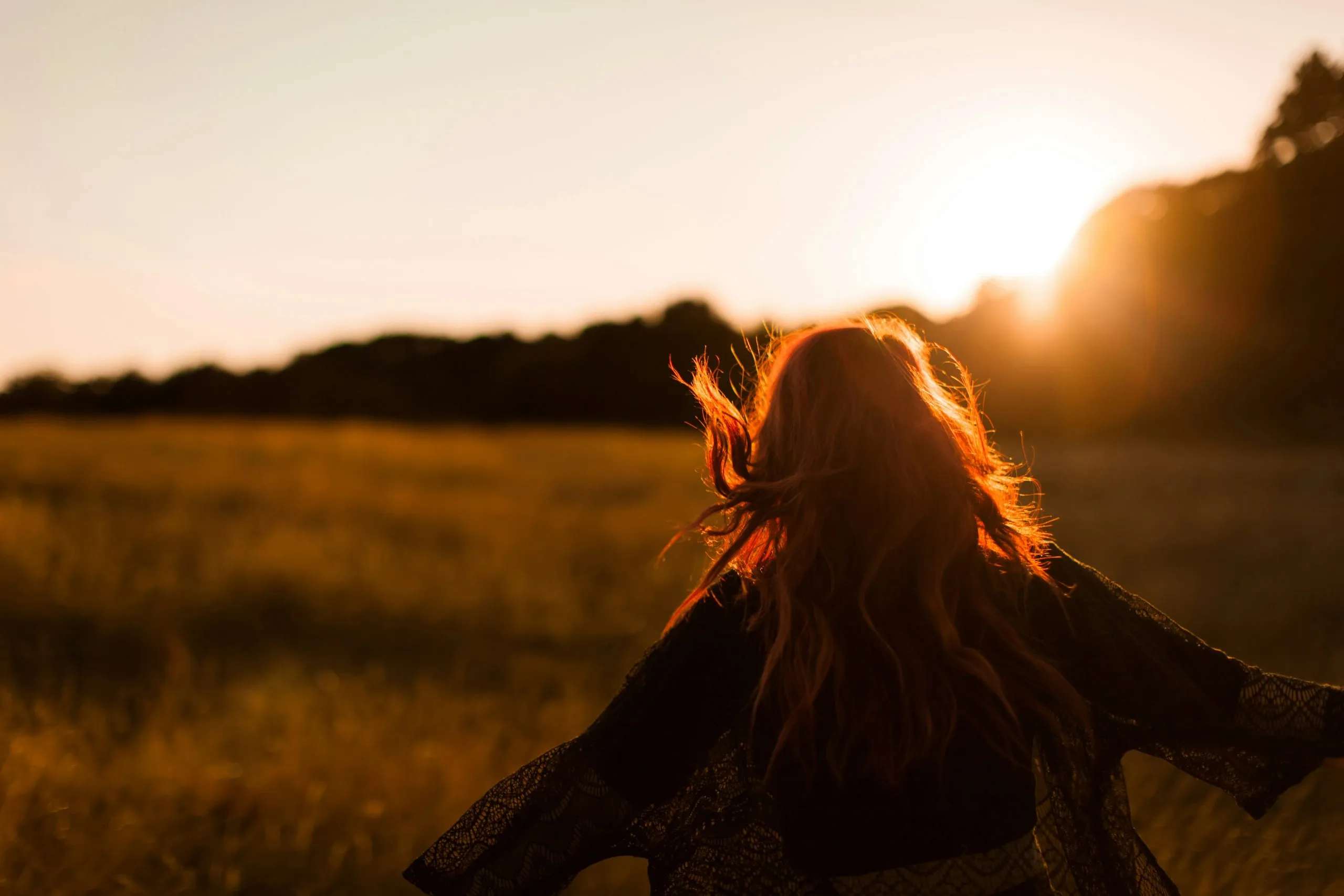 Frau mit offenem Haar im Gegenlicht der Abendsonne